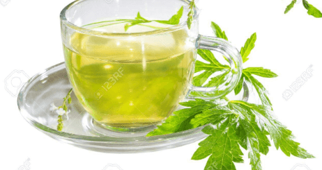 The picture shows a cup of green tea and its leaves